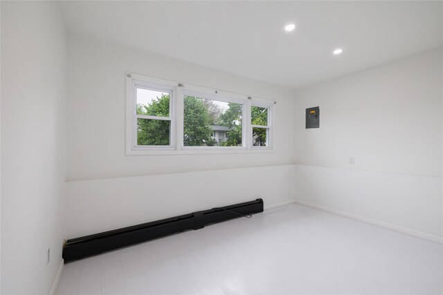 empty room with electric panel, recessed lighting, and baseboards