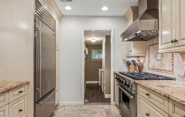 90 Gannet Dr, Commack, NY 11725 - kitchen with wall chimney exhaust hood, premium appliances, cream cabinets, backsplash, and recessed lighting