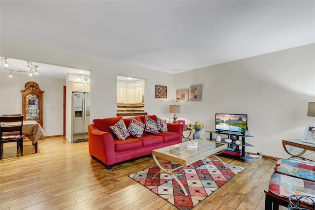 living room featuring light wood finished floors and baseboards