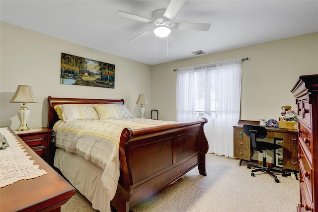 bedroom with light colored carpet, a desk, and a ceiling fan