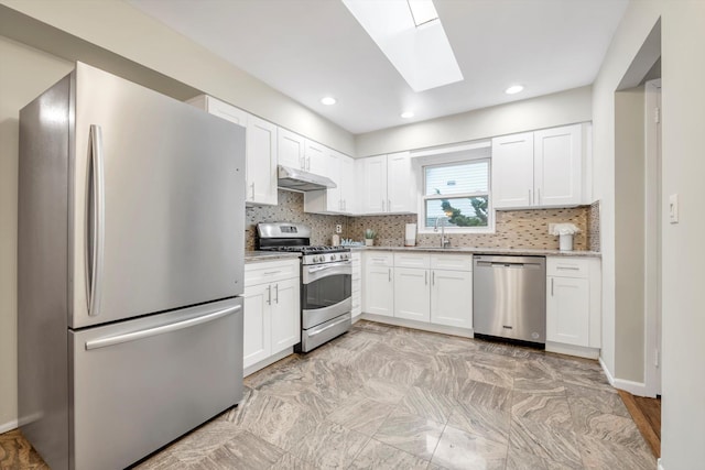 76 Melrose Ave, Lynbrook, NY 11563 - kitchen with appliances with stainless steel finishes, under cabinet range hood, a skylight, a sink, and white cabinetry
