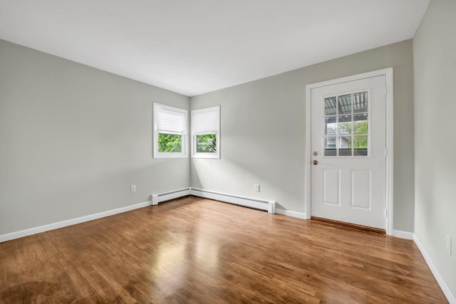 76 Melrose Ave, Lynbrook, NY 11563 - unfurnished room featuring healthy amount of natural light, wood finished floors, a baseboard heating unit, and baseboards