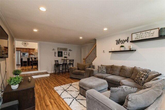 living area with stairway, crown molding, recessed lighting, wood finished floors, and baseboards