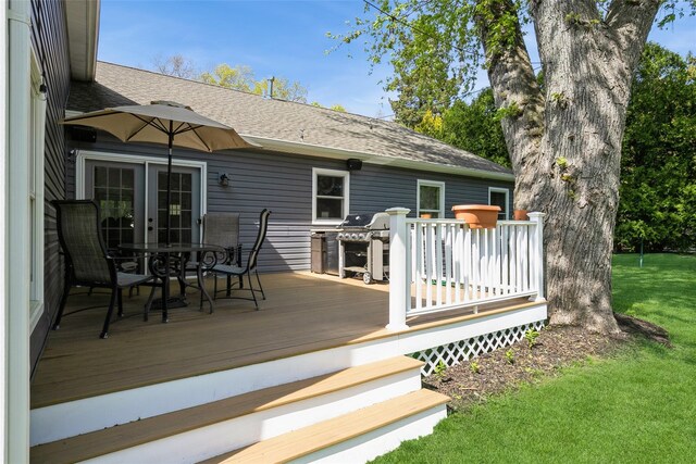 wooden deck with a lawn and outdoor dining area