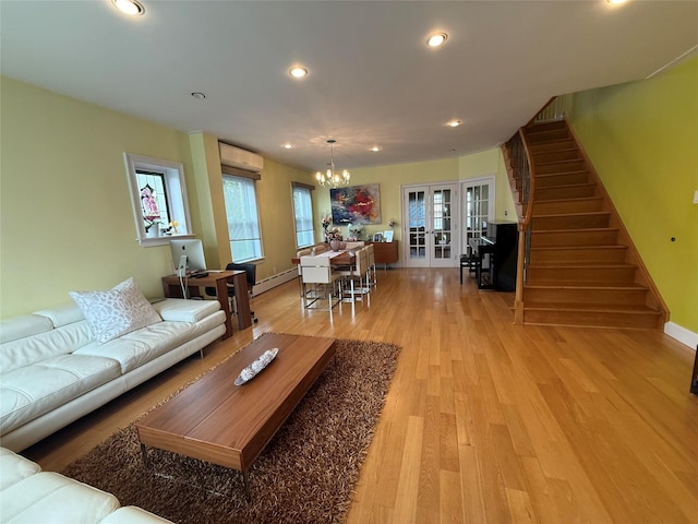 83-46 Penelope Ave, Middle Village, NY 11379 - living room with stairs, a chandelier, a wall mounted AC, french doors, and a baseboard radiator