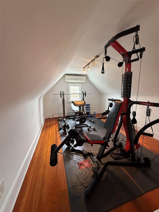 83-46 Penelope Ave, Middle Village, NY 11379 - workout area with lofted ceiling, wood finished floors, baseboards, a wall mounted AC, and rail lighting