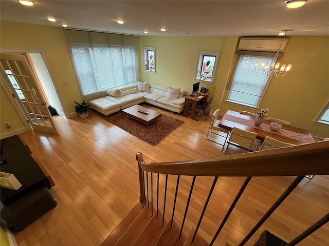 83-46 Penelope Ave, Middle Village, NY 11379 - living room with wood finished floors, a chandelier, an AC wall unit, baseboards, and recessed lighting