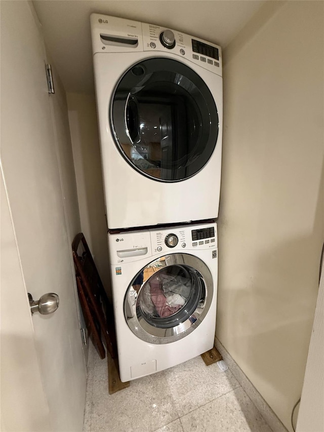83-46 Penelope Ave, Middle Village, NY 11379 - clothes washing area featuring stacked washer / drying machine and baseboards
