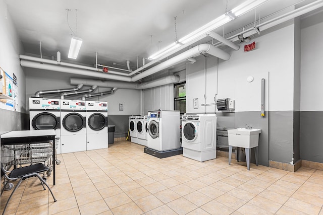 communal laundry room featuring washer and dryer and light tile patterned floors