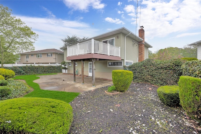 2228 Stacey Ct, North Bellmore, NY 11710 - back of property featuring a chimney, a patio, and a wooden deck