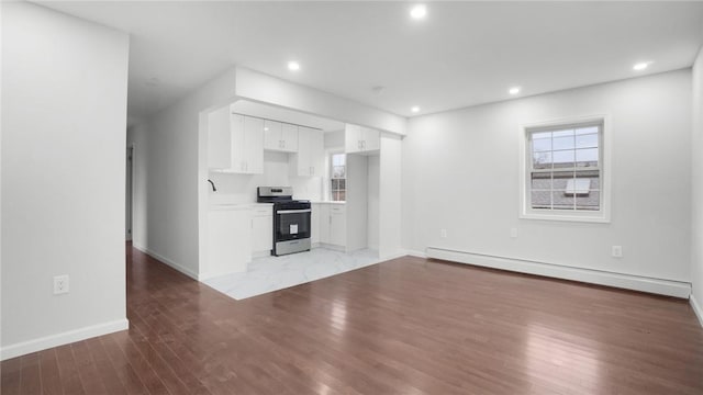 2155 Walton Ave, Bronx, NY 10453 - unfurnished living room featuring a baseboard heating unit, light wood finished floors, baseboards, and recessed lighting