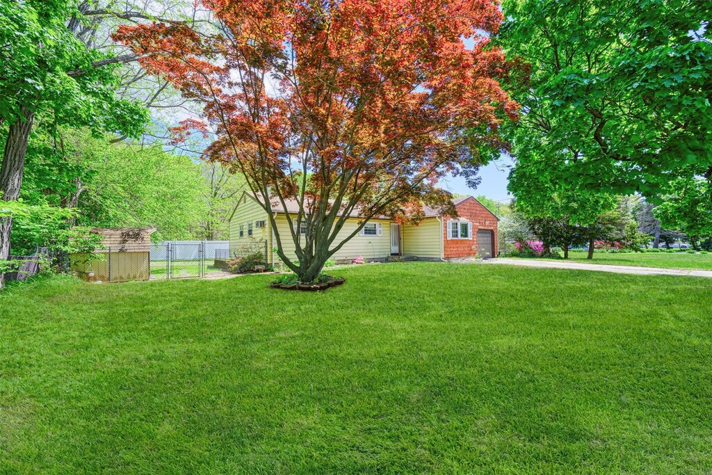 87 Bellwood Ave, South Setauket, NY 11720 - view of yard featuring a garage, a storage unit, an outbuilding, and concrete driveway