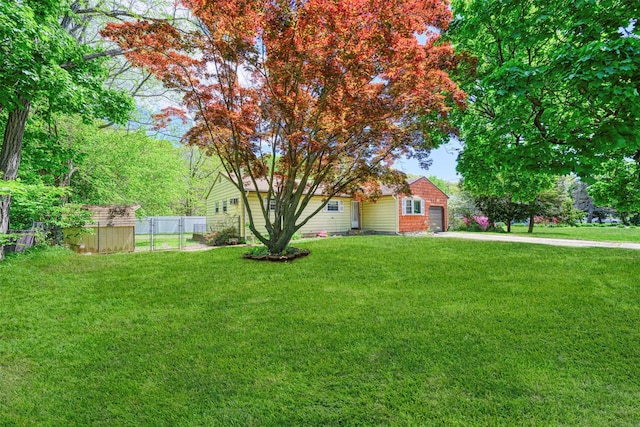 87 Bellwood Ave, South Setauket, NY 11720 - view of yard featuring a garage, a storage unit, an outbuilding, and concrete driveway