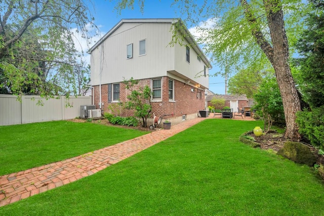 2346 Post St, East Meadow, NY 11554 - back of property with brick siding, central AC, an outdoor fire pit, and a patio