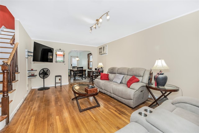 2733 Tenbroeck Ave, Bronx, NY 10469 - living area featuring arched walkways, light wood finished floors, stairs, a wall unit AC, and baseboards