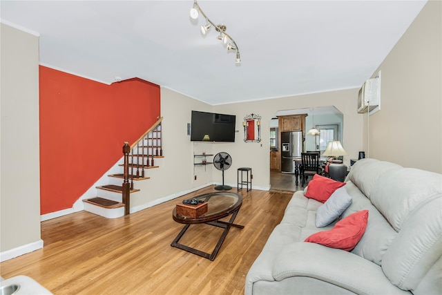 2733 Tenbroeck Ave, Bronx, NY 10469 - living room with wood finished floors, stairs, arched walkways, baseboards, and rail lighting