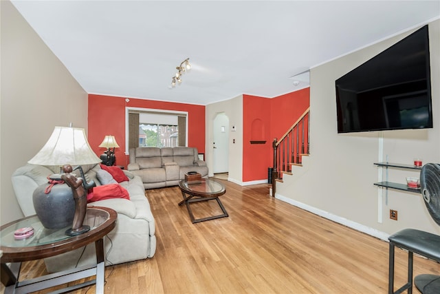 2733 Tenbroeck Ave, Bronx, NY 10469 - living room featuring arched walkways, stairs, wood finished floors, and baseboards