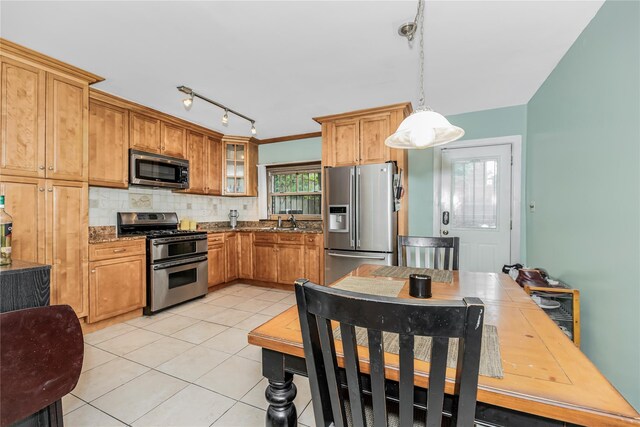 2733 Tenbroeck Ave, Bronx, NY 10469 - kitchen with stainless steel appliances, light tile patterned flooring, glass insert cabinets, decorative backsplash, and pendant lighting