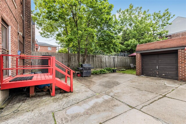 2733 Tenbroeck Ave, Bronx, NY 10469 - view of patio / terrace featuring area for grilling, a wooden deck, concrete driveway, a garage, and an outbuilding