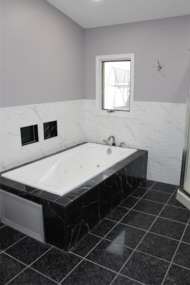 1535 Mattison St, Baldwin, NY 11510 - bathroom with tile patterned flooring, a tub with jets, a wainscoted wall, and tile walls