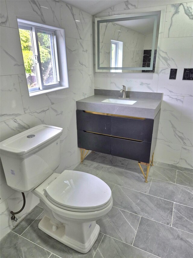 1535 Mattison St, Baldwin, NY 11510 - half bath featuring marble look tiles, tile walls, vanity, and toilet