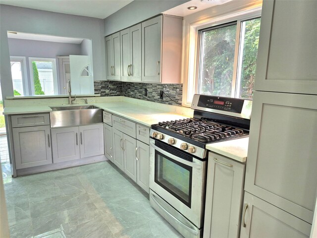 1535 Mattison St, Baldwin, NY 11510 - kitchen with stainless steel gas range oven, a sink, light countertops, and healthy amount of natural light