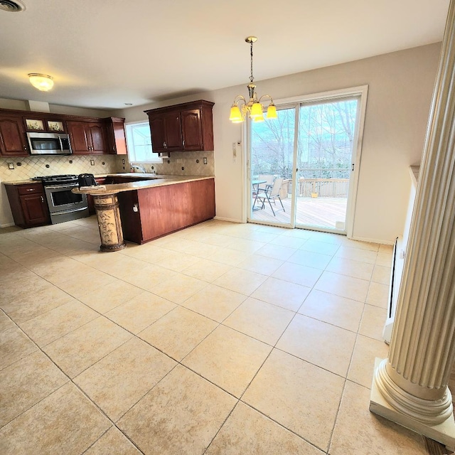 kitchen featuring stainless steel appliances, decorative backsplash, a peninsula, and a chandelier