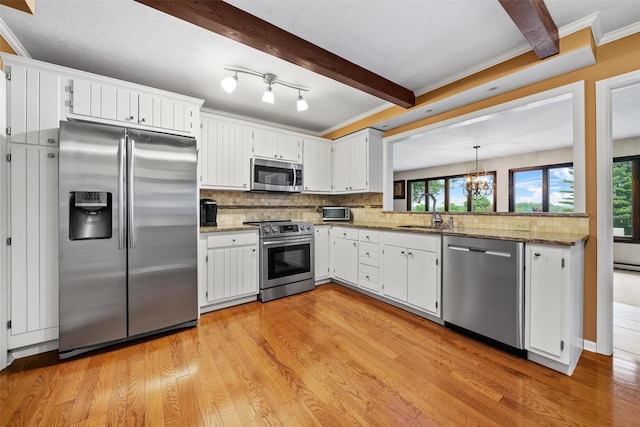 20 Idlewild Park Dr, Cornwall On Hudson, NY 12520 - kitchen with stainless steel appliances, a sink, decorative backsplash, a chandelier, and light wood finished floors