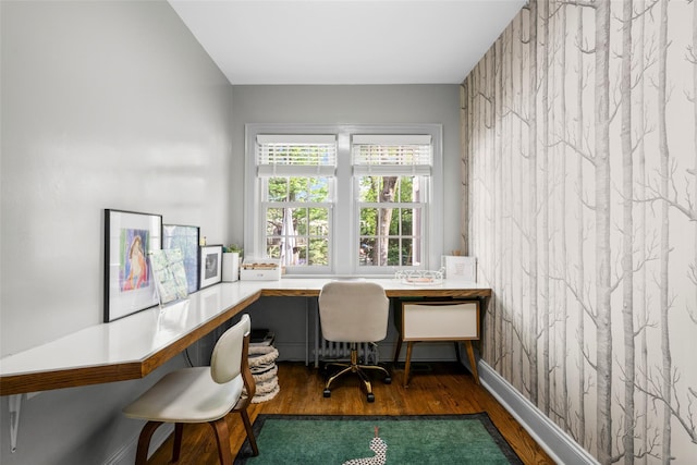 office space featuring wood finished floors and built in desk