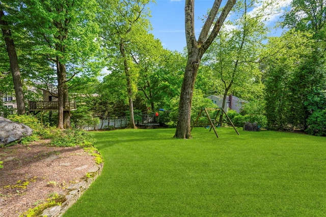 view of green lawn featuring a playground