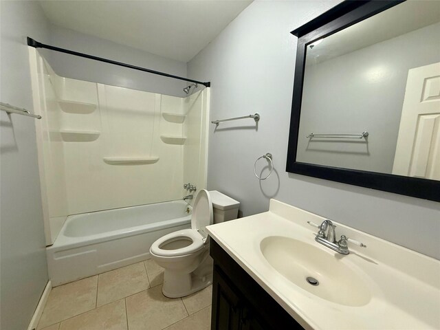 bathroom with tile patterned floors, toilet, vanity, baseboards, and  shower combination