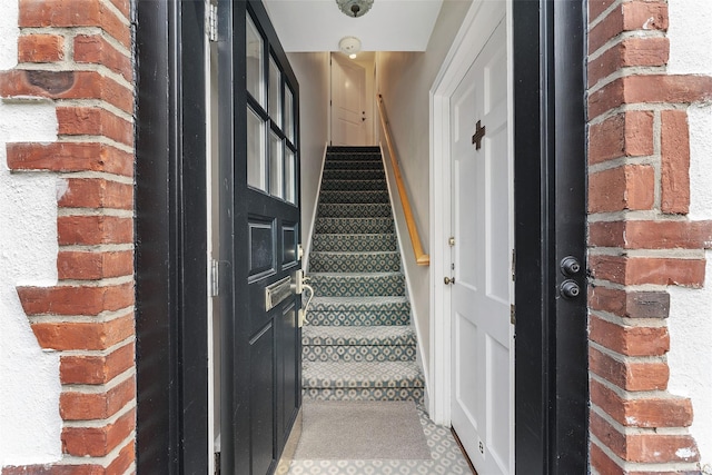 doorway to property featuring brick siding
