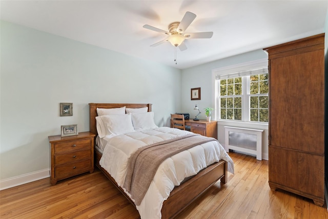 bedroom featuring light wood-style flooring, baseboards, and a ceiling fan