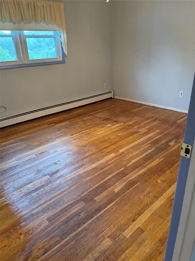 18 Prides Xing, Washingtonville, NY 10992 - empty room featuring a baseboard heating unit, hardwood / wood-style floors, and baseboards