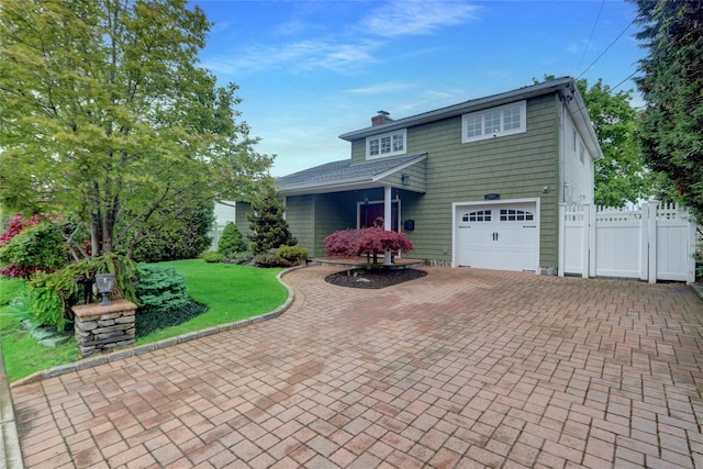 view of front of property with decorative driveway, a chimney, and an attached garage