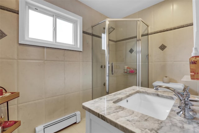 full bathroom featuring baseboard heating, tile walls, a shower stall, vanity, and tile patterned floors