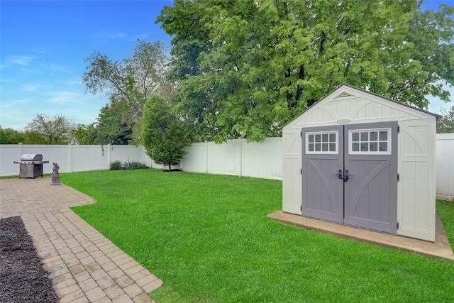 view of yard with an outdoor structure, a shed, and a patio area