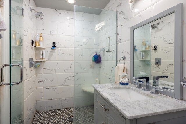 bathroom with a stall shower, tile walls, and vanity