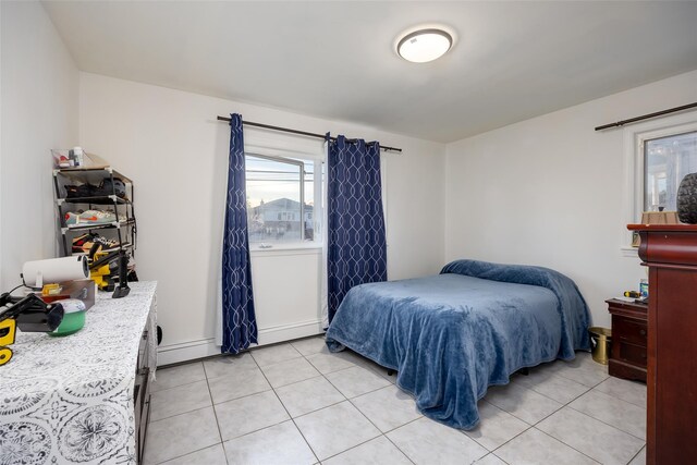 bedroom featuring light tile patterned flooring and a baseboard radiator