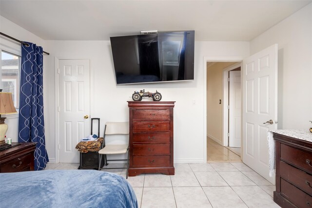 bedroom with light tile patterned floors and baseboards
