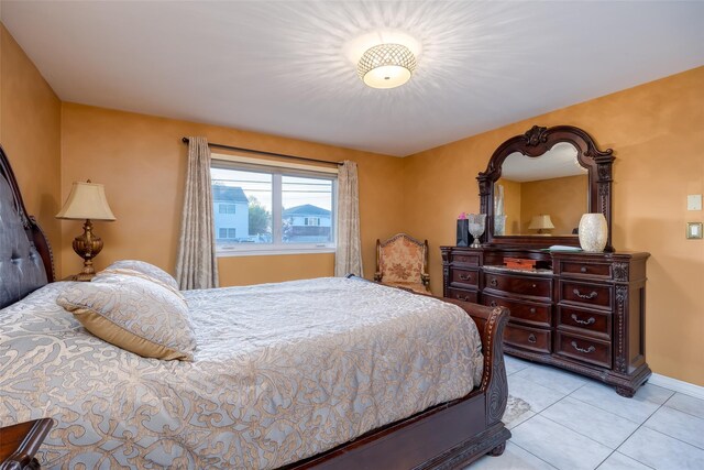 bedroom featuring light tile patterned floors and baseboards