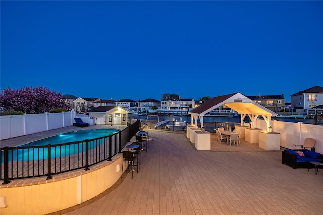 view of swimming pool with fence, a gazebo, and a residential view