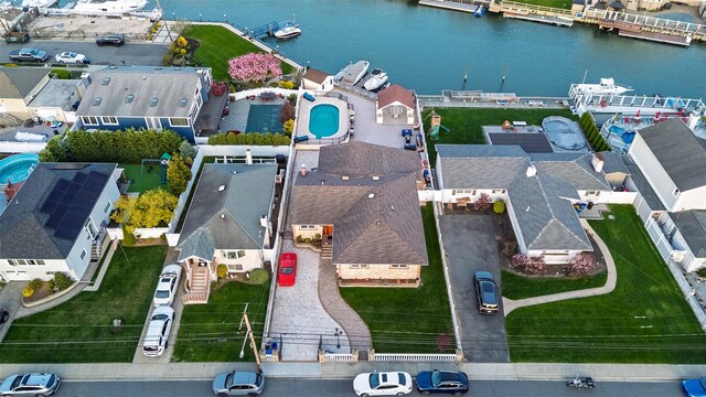 aerial perspective of suburban area with a nearby body of water and a pool