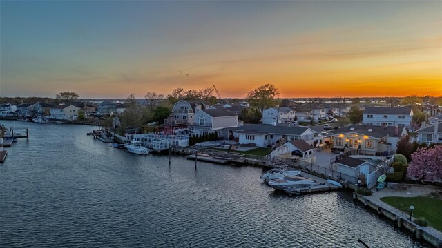 water view featuring nearby suburban area and a boat dock