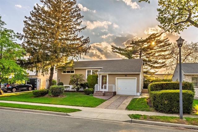tri-level home with a garage, driveway, and a lawn