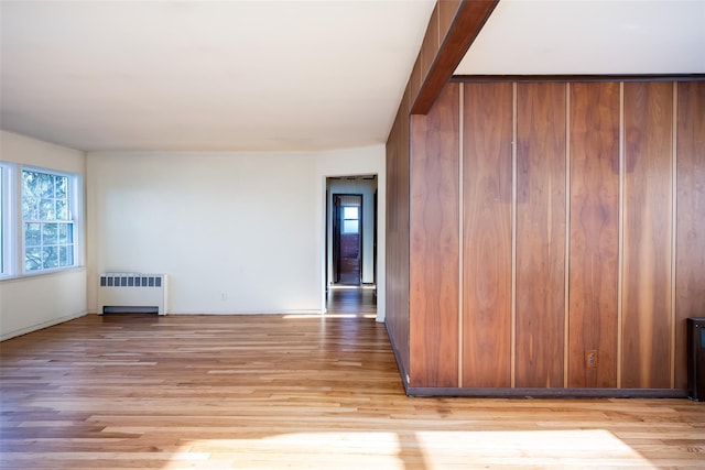 unfurnished room featuring radiator and light wood-style flooring