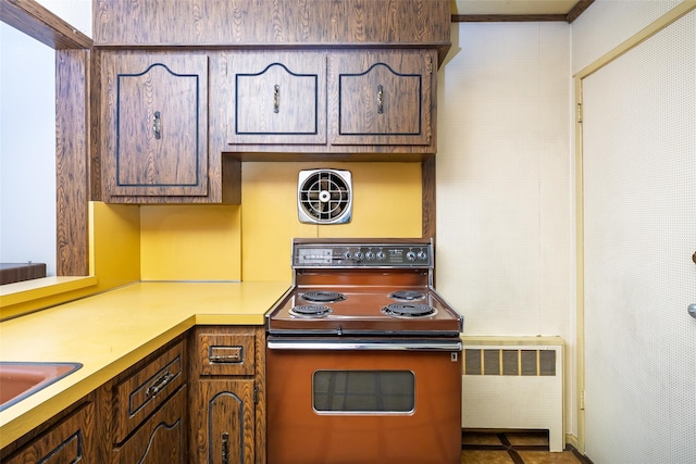 kitchen with electric range, radiator, light countertops, and dark brown cabinets
