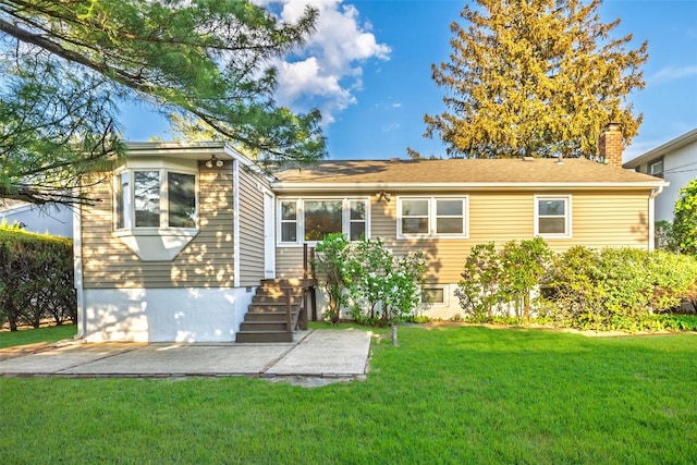 rear view of property featuring a lawn, a patio, and a chimney