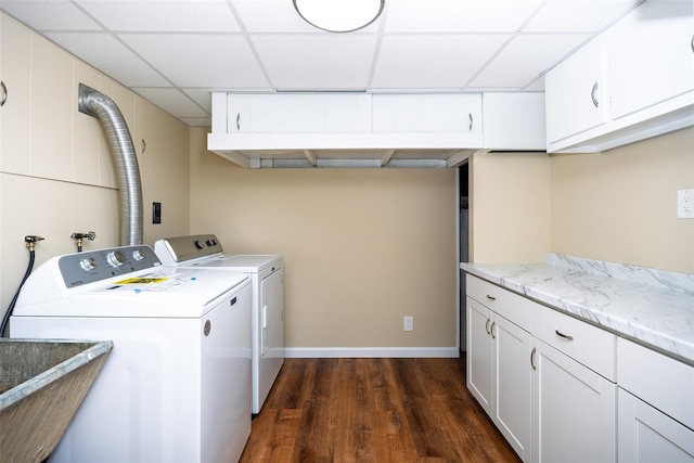laundry room featuring cabinet space, dark wood-style floors, washing machine and dryer, and baseboards