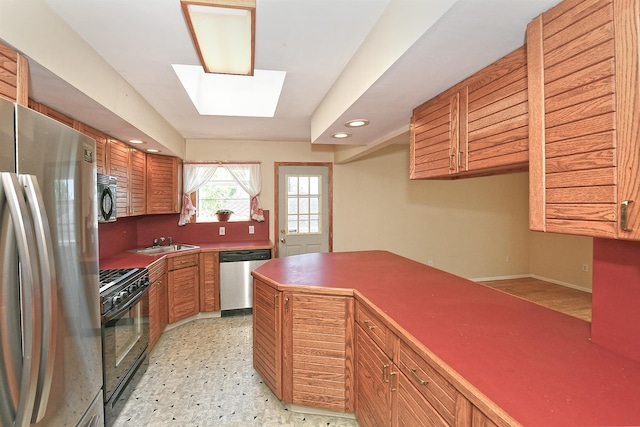 64 S Nassau St, Bethpage, NY 11714 - kitchen with stainless steel appliances, a sink, recessed lighting, a skylight, and brown cabinets